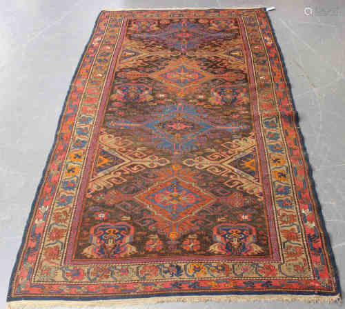 A Caucasian sumak rug, early 20th century, the dark chestnut field with four hooked medallions