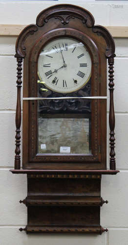 A late 19th century American walnut cased wall clock, the movement striking on a gong, the case with