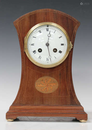 An Edwardian mahogany mantel clock with eight day movement striking on a gong, the circular enamel