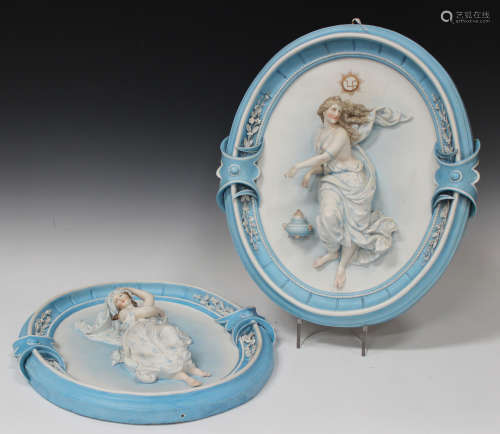 A large pair of French bisque porcelain oval wall plaques, circa 1900, each moulded in high relief