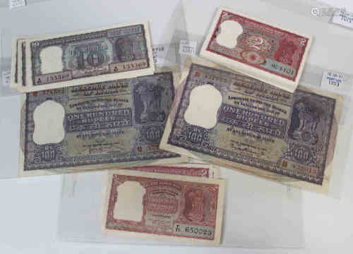 A collection of Indian banknotes, including two Reserve Bank of India one hundred rupees and a