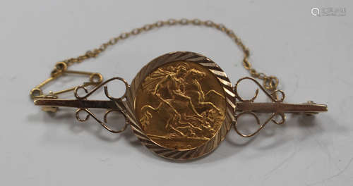 A George V half-sovereign 1913 in a 9ct gold brooch mount, decorated with scroll pierced sides,