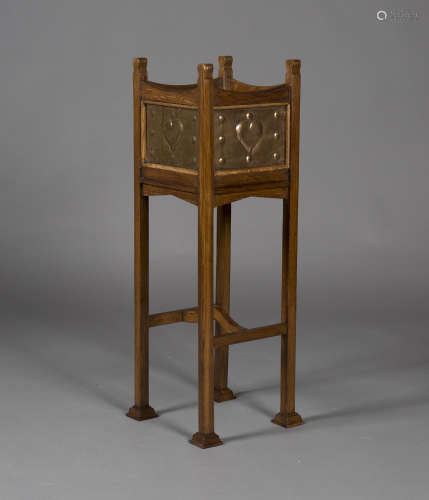 An Edwardian Arts and Crafts oak framed and copper inset jardinière stand, the square body inset