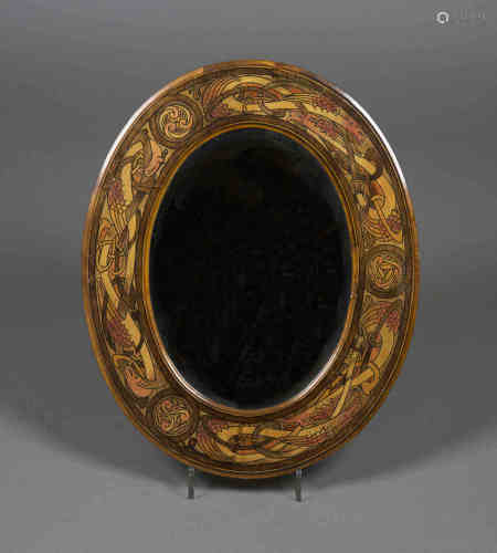 An early 20th century Arts and Crafts penwork oval wall mirror, possibly Irish, the bevelled plate