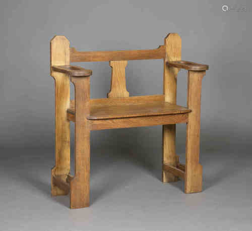 An Edwardian Arts and Crafts oak hall bench, possibly by Liberty & Co, the shaped back supports
