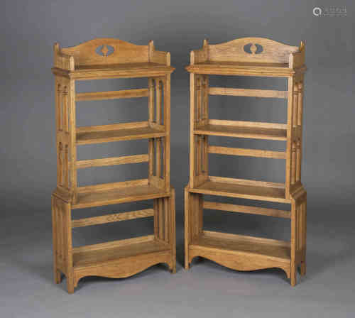 A very near pair of Edwardian Arts and Crafts oak four-tier open bookcases, attributed to Wylie &