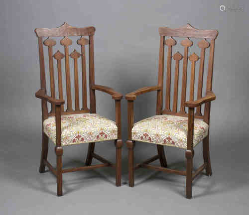 A pair of Edwardian Arts and Crafts oak framed elbow chairs by Allen & Appleyard of Liverpool, the