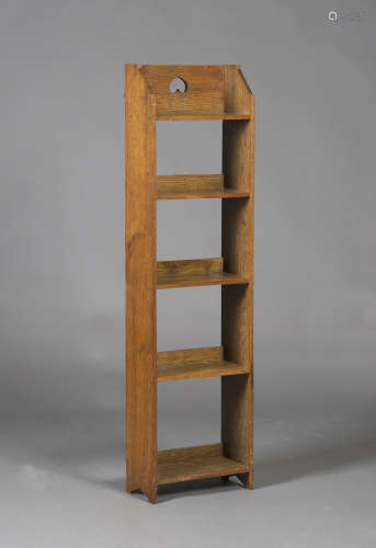 An early 20th century Arts and Crafts oak open bookcase, the gallery back with a pierced inverted