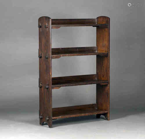 An early 20th century Arts and Crafts stained oak four-tier open bookcase of pegged construction,