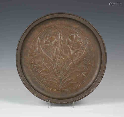 An early 20th century Arts and Crafts copper circular dish, worked with an overall stylized