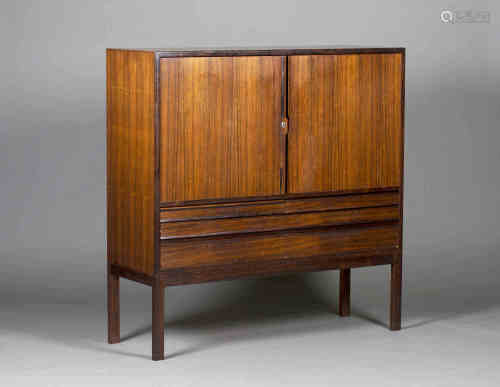 A mid-20th century rosewood side cabinet, possibly by Gordon Russell, the two doors enclosing four