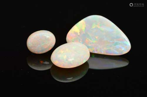 A SELECTION OF THREE PRECIOUS WHITE OPALS, flashes of blues, greens, yellow and orange seen on