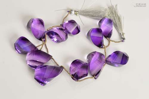 AMETHYST TWISTED DROP BEADS, briolette shape, comprising eleven beads, strung on 190mm string, beads