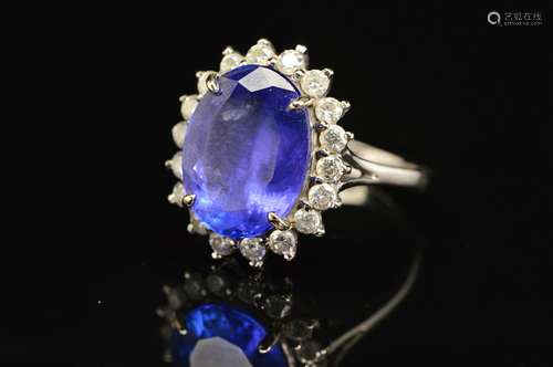 A MODERN LARGE TANZANITE AND DIAMOND OVAL CLUSTER RING, tanzanite measuring approximately 14.3mm x