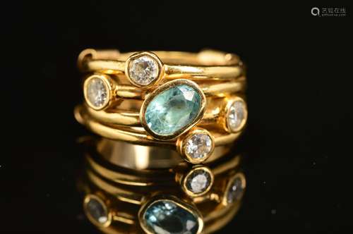 A MODERN DIAMOND AND BLUE ZIRCON DRESS RING, comprised four gold bands rub over set with one oval