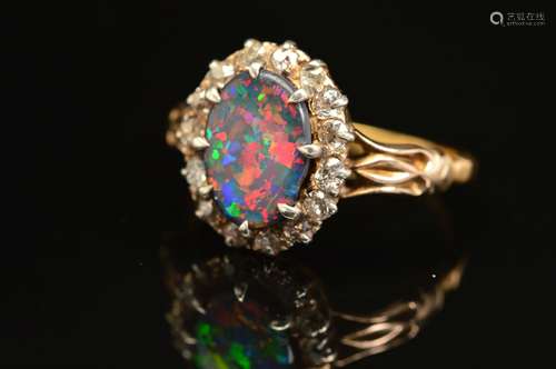 A GOLD EARLY 20TH CENTURY FINE BLACK OPAL AND DIAMOND RING, centring on an oval black oval,