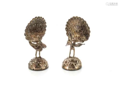 A pair of early 20th century Indian silver models of birds, the peacocks with flaring tail