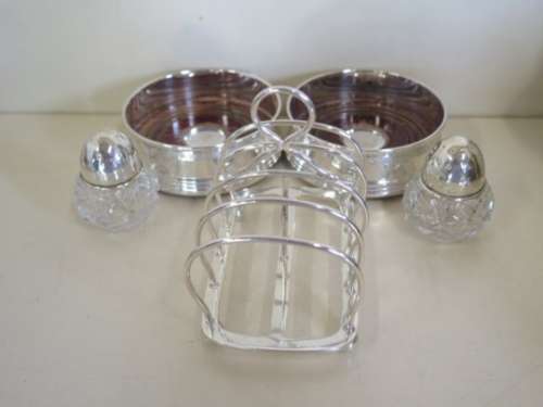 A silver toast rack, approx 4 troy oz, a pair of silver coaster and a pair of silver top peppers