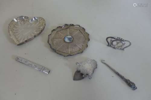 A silver pin tray, in the shape of a heart and another in the shape of a lily pad, menu holder,