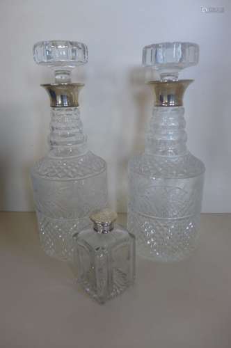 Two cut glass and engraved decanters with silver rims, 28cm tall and a scent bottle, all generally