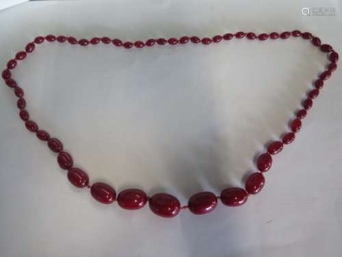 A string of cherry amber/Bakelite beads, approx 90cm long, largest bead 3x2cm - aprox 76 grams, in