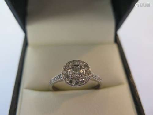 A pretty platinum diamond cluster ring in a modern setting, the central diamond measuring approx 0.