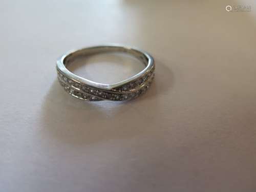 A platinum and diamond half eternity crossover ring, set with 35 round cut diamonds totaling 0.36ct,