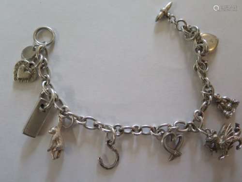 A silver joy charm bracelet, set with eight charms, T-bar style clasp, length 19cm, approx weight