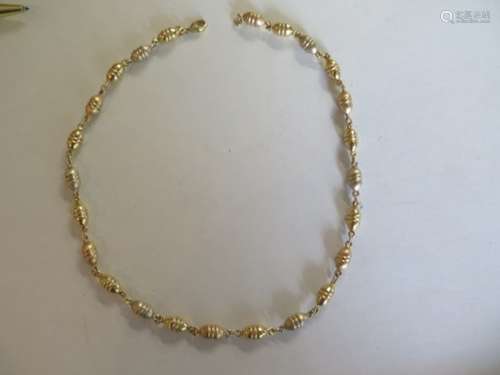 An 18ct gold oval bead necklace, in three colours of gold, stamped 750 and full hallmarks, length