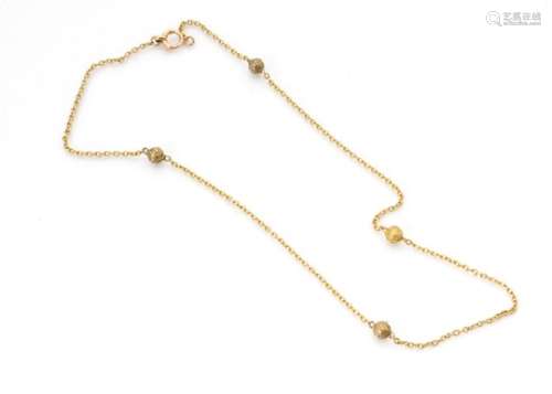 A Victorian 15ct gold necklace, the oval links set with four filigree decorated yellow metal beads