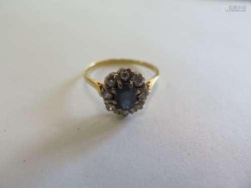 An 18ct yellow gold diamond and sapphire ring, the central sapphire approx 7.5mm x 4.8mm x 3.2mm,