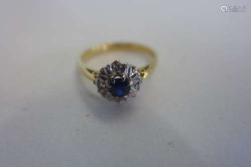 An 18ct yellow gold sapphire and diamond ring, set with a single sapphire, in white gold setting,