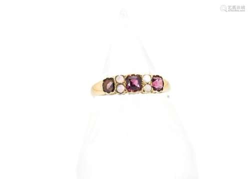 An early 20th Century 18ct gold garnet and opal dress ring, the three cushion cut garnets