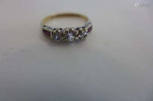 A 9ct ladies ring set with three white stones, in a platinum mount, with baguette cut rubies to