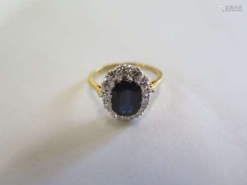 An 18ct gold sapphire and diamond ring, the central sapphire approx 8.5mm x 6.5mm x 3.5mm -