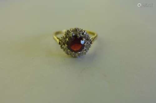 A pretty 18ct gold diamond cluster ring, with central red stone, surrounded by ten diamonds, size P,