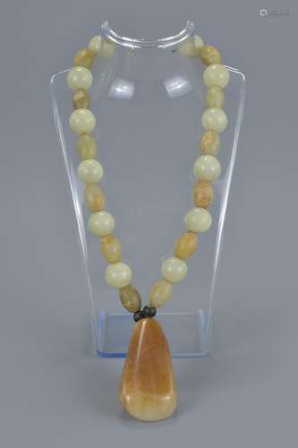 A jade beaded necklace with agate pendant.