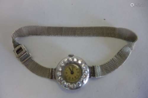 A ladies platinum cased wristwatch set with white stones, Swiss un-named movement, the strap is gold