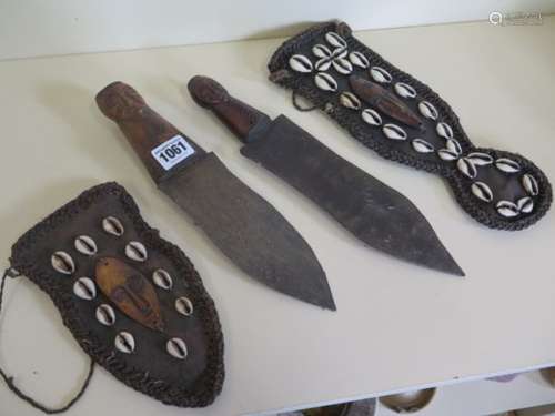 Two African iron daggers with polished carved cow bone handles, leather scabbard decorated with