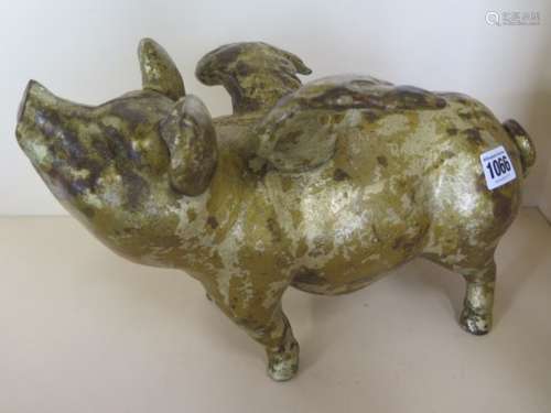 A cast iron flying pig money box with gold paint finish, length 33cm, weight 22cm