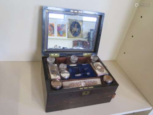 A 19th century coromandel travel box with fitted interior of plated top bottles and manicure pieces,