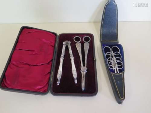 A set of four bright cut steel scissors in leather case, and a boxed set of plated nut crackers, and