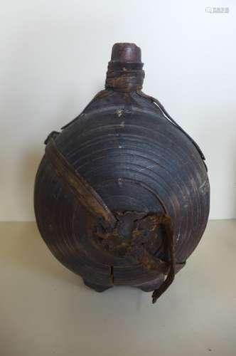 A carved moon shaped wooden flask, 26cm tall, with remains of leather strapping, general wear and