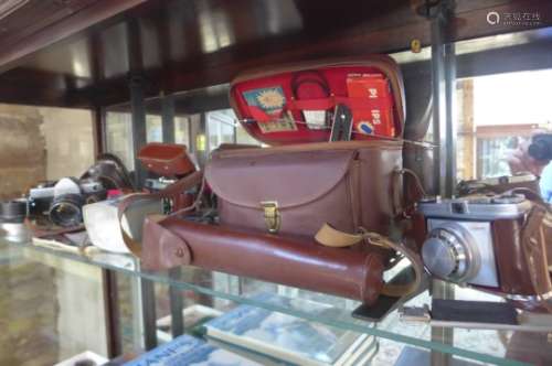 A Kodak Retinette camera case and kit, a Minolta SR-7 and a Cosmic 35 camera
