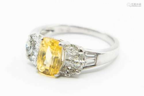 A YELLOW SAPPHIRE AND DIAMOND RING, the oval cut yellow