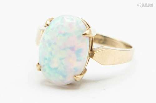 A 9CT YELLOW GOLD AND OPAL RING, the oval cut opal claw