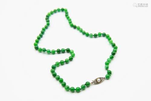 A JADEITE BEAD NECKLACE, the seventy uniform jadeite