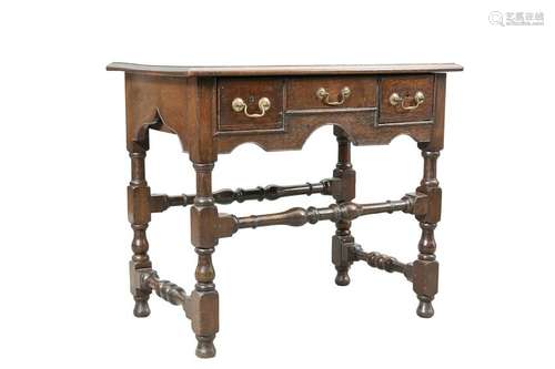 AN OAK LOWBOY, the moulded rectangular top above three