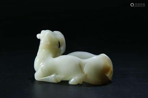 A PALE CELADON/RUSSET JADE CARVING OF RAM