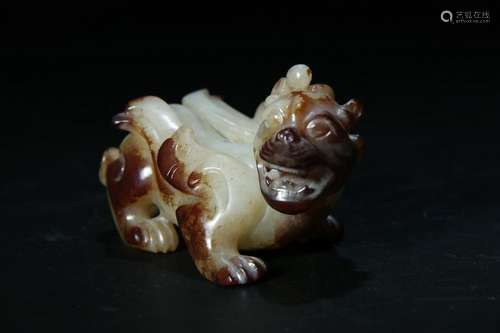 A PALE CELADON/RUSSET JADE CARVING OF A BEAST